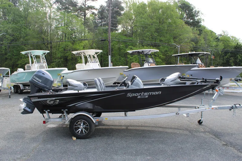 Slide: The Image of 2025 G3 Sportsman 1610 boat on trailer, parked outdoors with trees in background. - 6