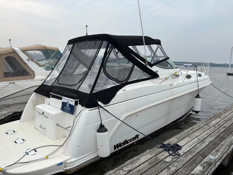 Slide: The Image of 1998 Wellcraft 3000 Martinique boat docked, featuring a sleek design and protective canopy. - 0