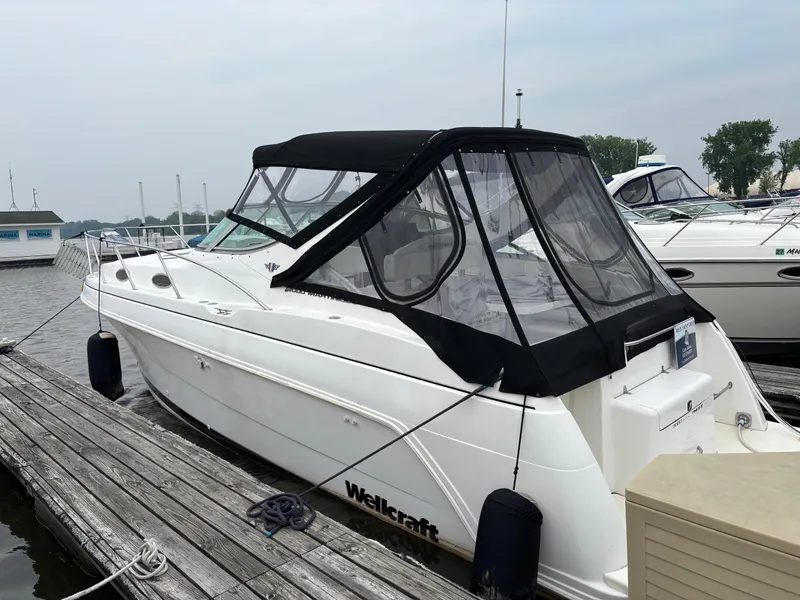 Slide: The Image of 1998 Wellcraft 3000 Martinique boat docked at marina with black canopy. - 1