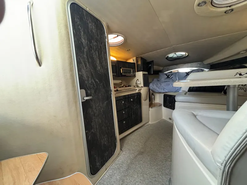 Slide: The Image of Interior of 1998 Wellcraft 3000 Martinique boat, featuring kitchen and seating area. - 12