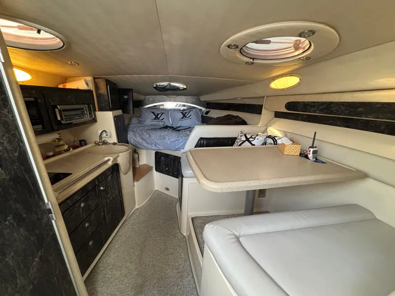 Slide: The Image of 1998 Wellcraft 3000 Martinique cabin interior with kitchenette, seating, and bed. - 13