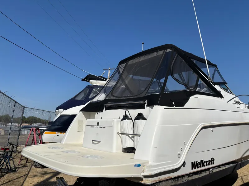 Slide: The Image of 1998 Wellcraft 3000 Martinique boat docked, featuring sleek design and spacious deck. - 20