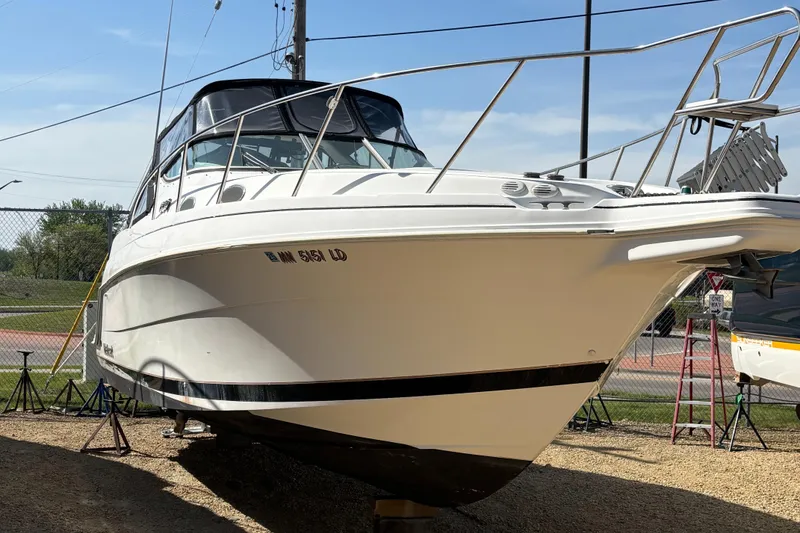 Slide: The Image of 1998 Wellcraft 3000 Martinique boat on display, white hull, outdoor setting. - 3