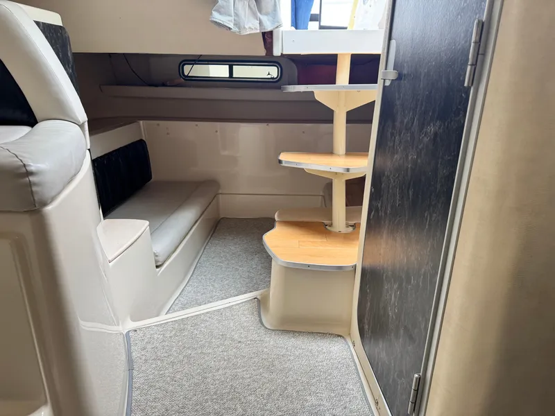 Slide: The Image of 1998 Wellcraft 3000 Martinique cabin interior with seating and wooden steps. - 5