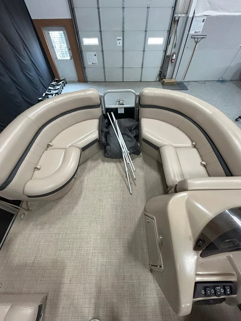 Slide: The Image of 2018 South Bay 220FCR pontoon boat interior with beige seating in a garage. - 10