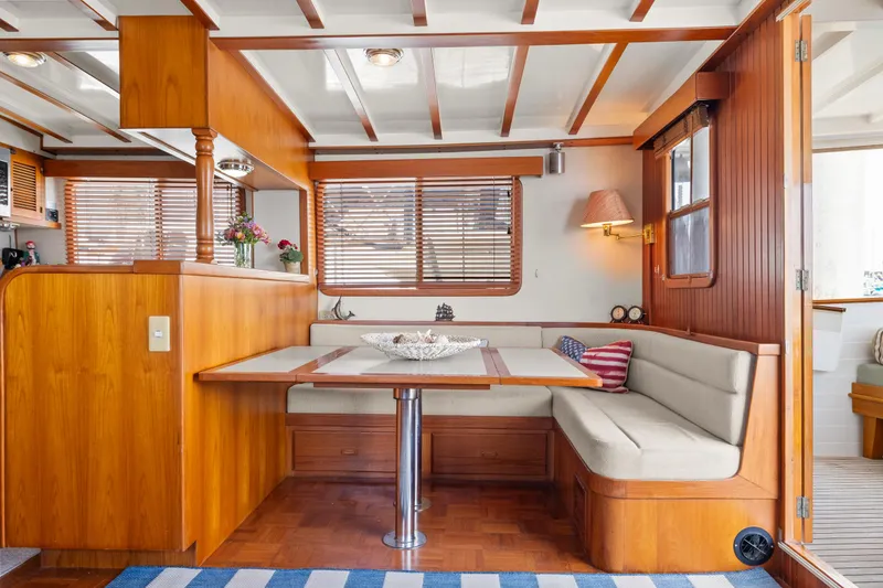 Slide: The Image of Interior of 1996 Kadey-Krogen 48 Whaleback yacht with wooden dining area and cozy seating. - 16