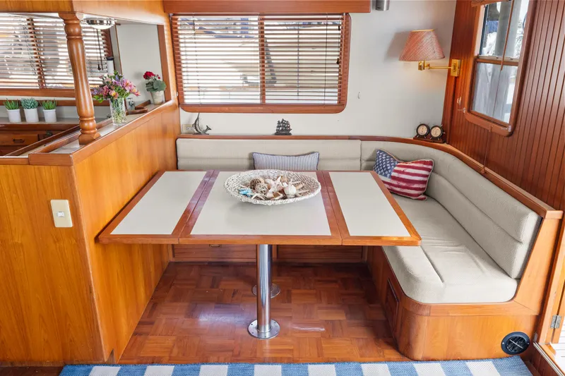 Slide: The Image of Cozy dining area in 1996 Kadey-Krogen 48 Whaleback yacht with wooden accents and nautical decor. - 19