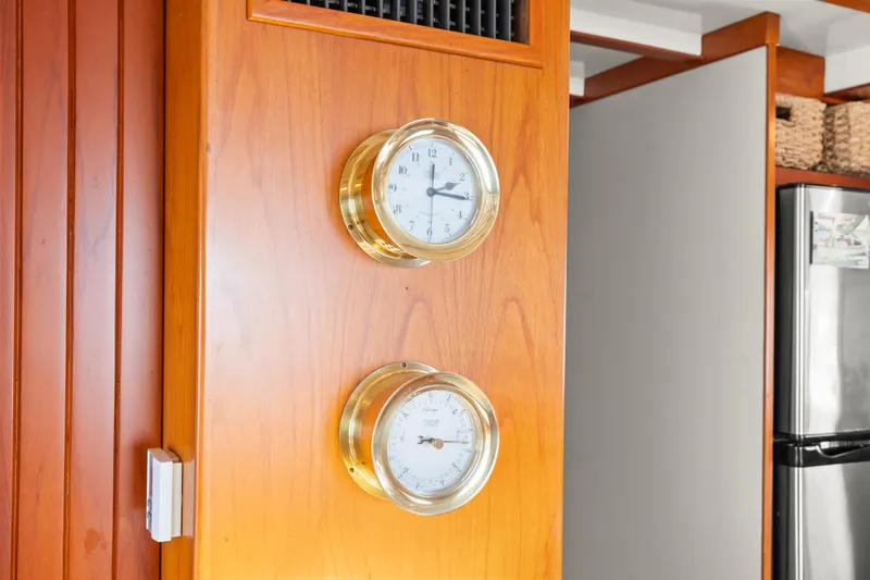 Slide: The Image of Brass clock and barometer on Kadey-Krogen 48 Whaleback, 1996, wooden interior. - 26