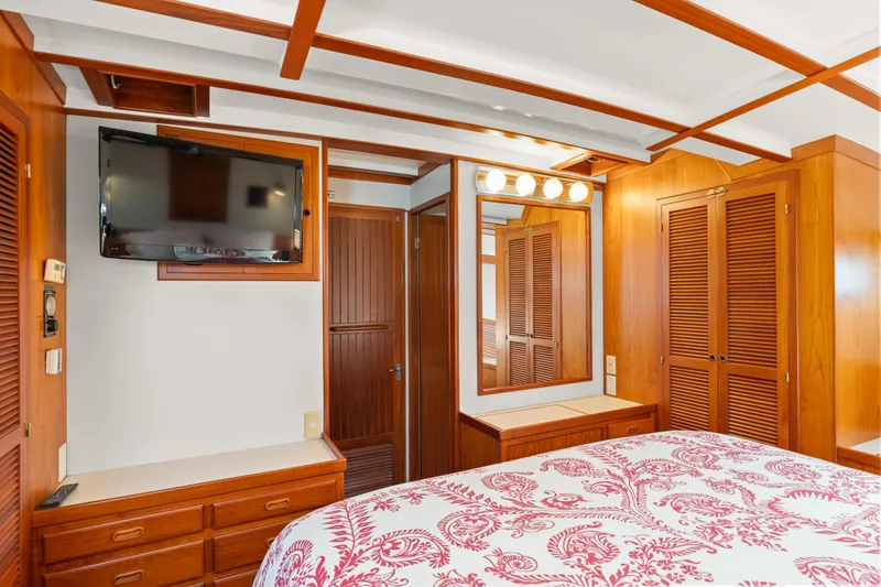 Slide: The Image of Luxurious 1996 Kadey-Krogen 48 Whaleback bedroom with wood paneling and floral bedding. - 47