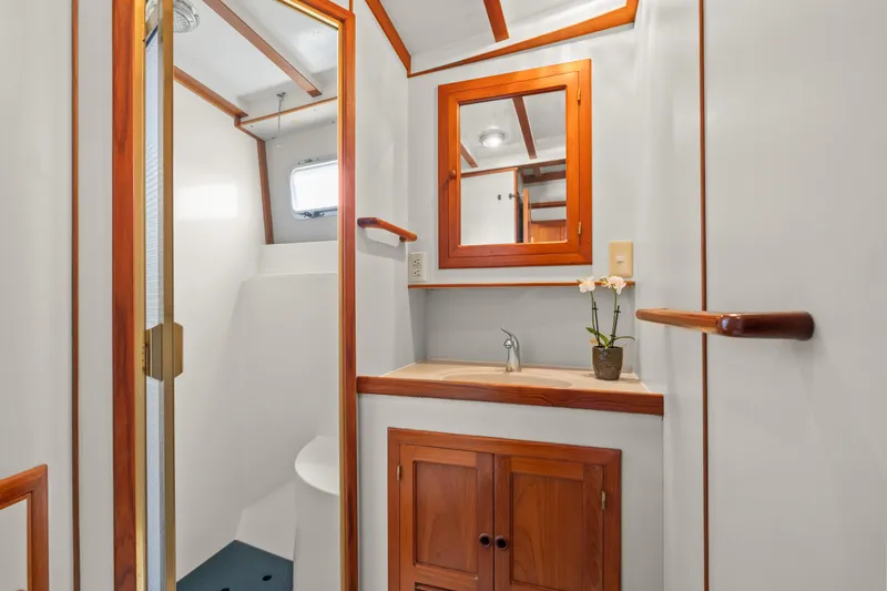 Slide: The Image of Bathroom interior of 1996 Kadey-Krogen 48 Whaleback yacht with wooden accents and mirror. - 48