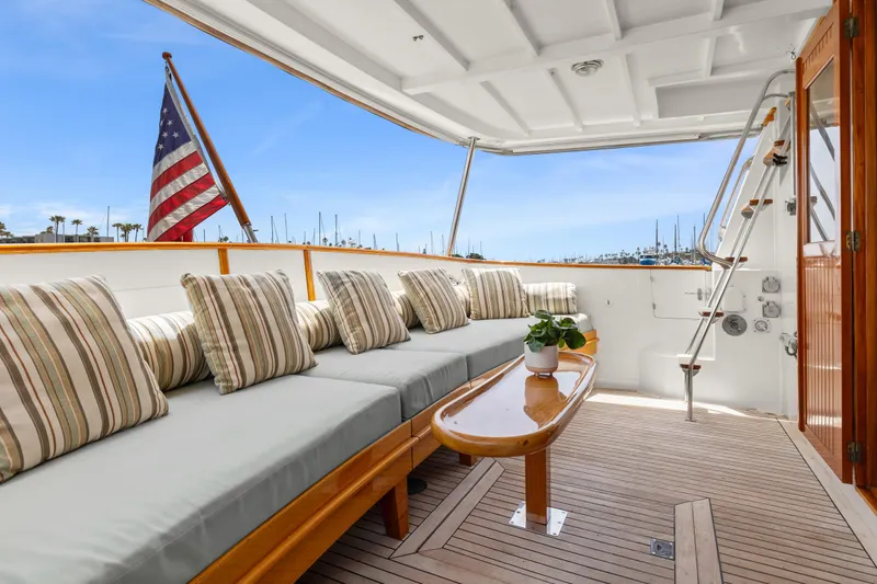 Slide: The Image of Kadey-Krogen 48 Whaleback 1996 yacht deck with cushioned seating and American flag. - 7