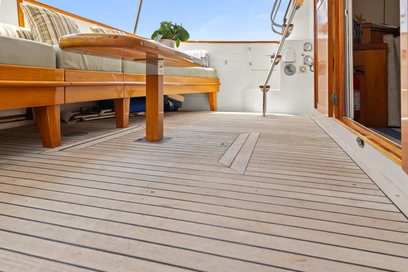 Slide: The Image of Kadey-Krogen 48 Whaleback 1996 yacht deck with wooden seating and open cabin door. - 8