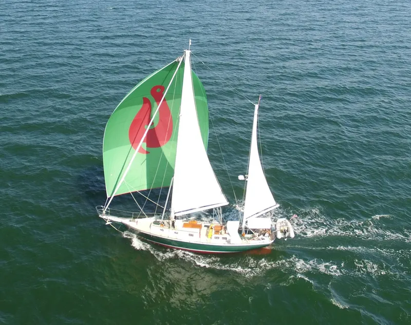 The Image of Sailing yacht Cherubini 44 (1979) with green spinnaker on open sea. - 0