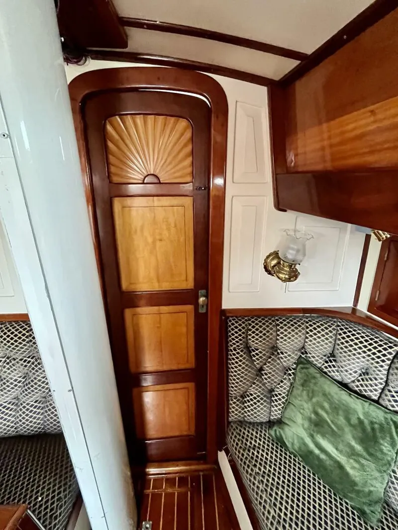 Slide: The Image of Interior of a 1979 Cherubini 44 sailboat with wood paneling and cushioned seating. - 13