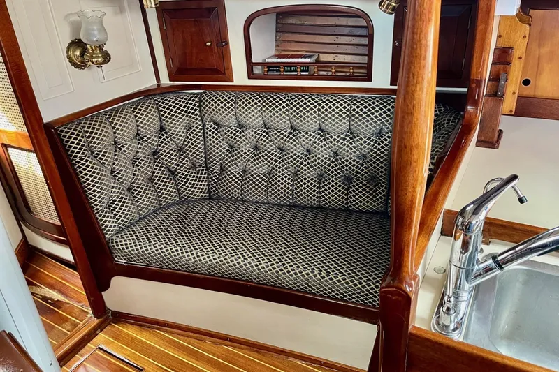 Slide: The Image of Interior of 1979 Cherubini 44 sailboat with cushioned seating and wooden accents. - 15