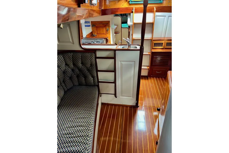 Slide: The Image of Interior of 1979 Cherubini 44 sailboat with polished wood flooring and compact kitchen. - 16