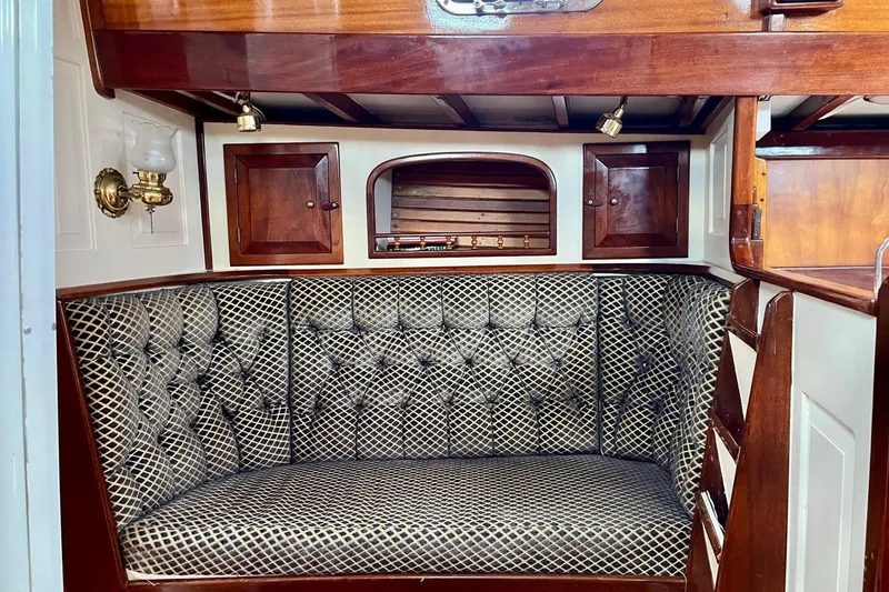 Slide: The Image of Cozy interior of 1979 Cherubini 44 sailboat with tufted seating and wooden cabinetry. - 17