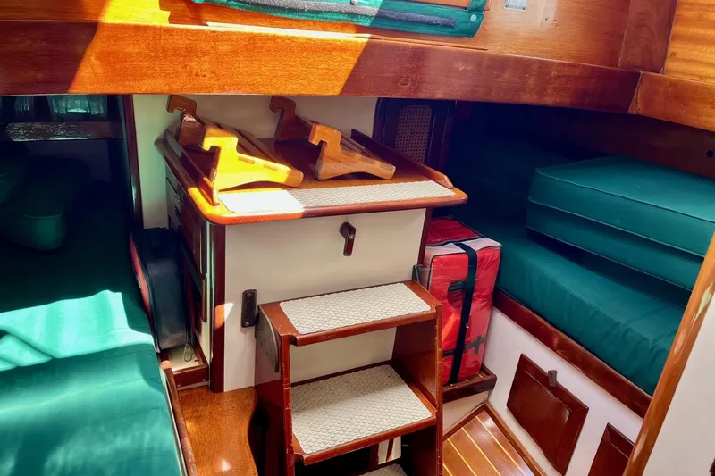 Slide: The Image of Interior of 1979 Cherubini 44 sailboat with wooden steps and green cushions. - 20
