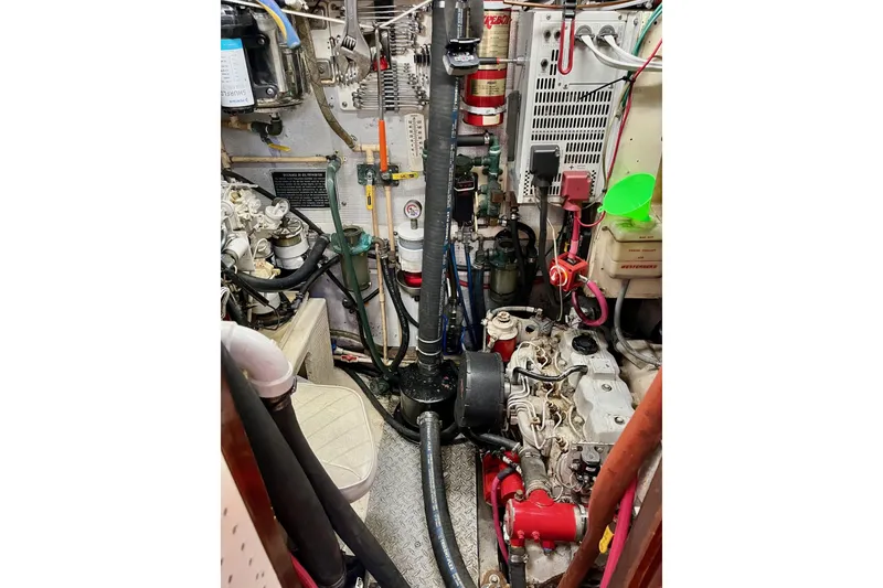 Slide: The Image of Engine room of a 1979 Cherubini 44 sailboat, showcasing mechanical components and wiring. - 28