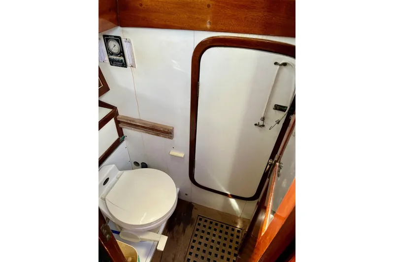 Slide: The Image of 1979 Cherubini 44 yacht bathroom with toilet, wooden accents, and nautical decor. - 30