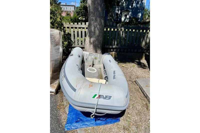 Slide: The Image of Gray inflatable boat on blue tarp, outdoors near a wooden fence. - 34