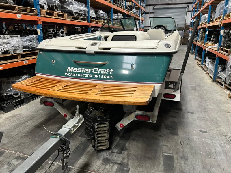 Slide: The Image of 1996 MasterCraft 205 Pro Star ski boat in warehouse, featuring wooden swim platform. - 7