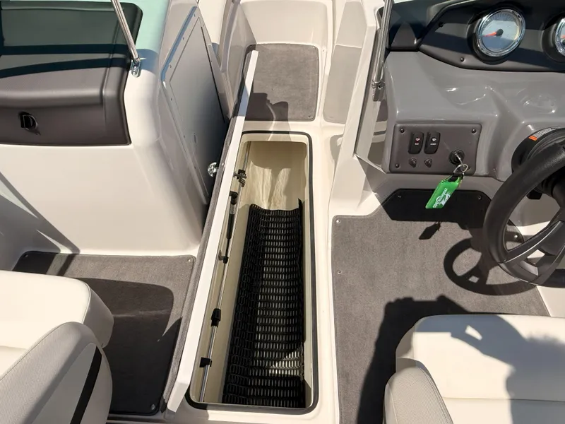 Slide: The Image of 2016 Yamaha Boats SX190 interior showing storage compartment and dashboard controls. - 14