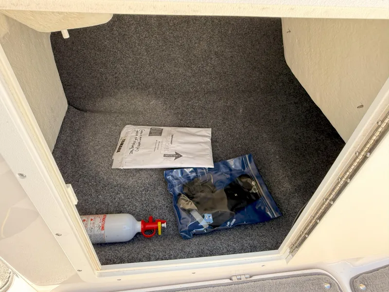 Slide: The Image of Storage compartment of 2016 Yamaha SX190 boat with fire extinguisher and documents. - 15