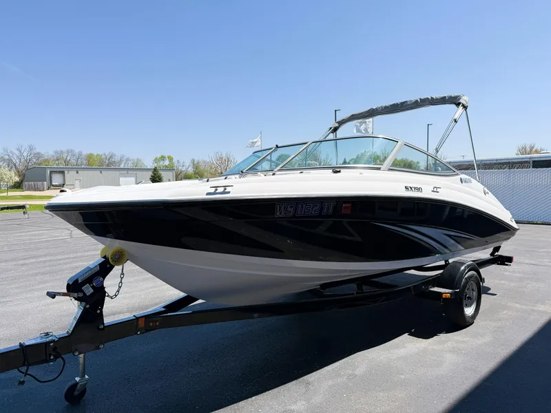 Slide: The Image of 2016 Yamaha Boats SX190 on trailer, parked outdoors under clear blue sky. - 2