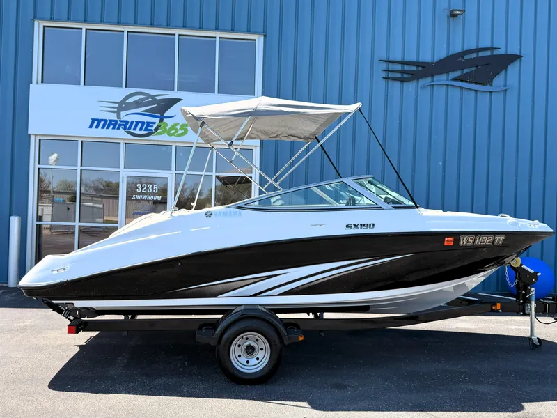 Slide: The Image of 2016 Yamaha SX190 boat with canopy on trailer, parked outside Marine365 building. - 21