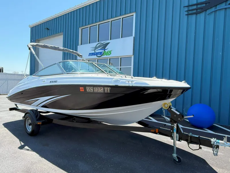 Slide: The Image of 2016 Yamaha SX190 boat on trailer outside a blue building. - 3