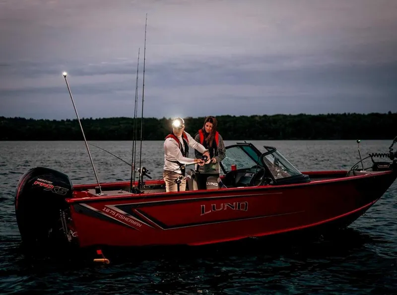 Slide: The Image of 2026 Lund 1875 Fisherman boat on water at dusk with two people fishing. - 1