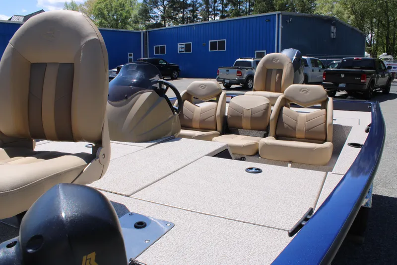 Slide: The Image of 2025 G3 Sportsman 1710 boat with beige seating, parked outdoors near blue building. - 11