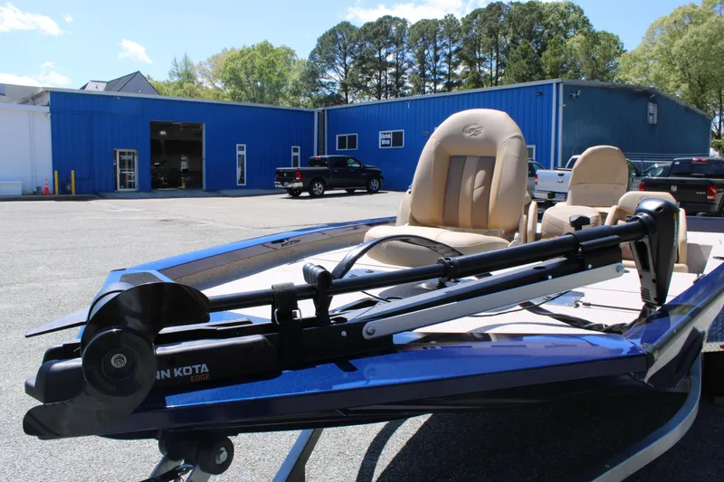 Slide: The Image of 2025 G3 Sportsman 1710 boat with Minn Kota motor, parked outside blue building. - 9