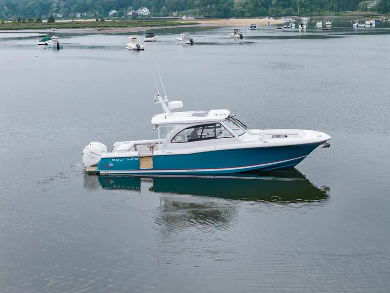 Slide: The Image of 2021 Southport 33 DC boat on calm water with scenic background. - 14