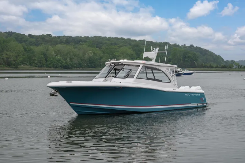 Slide: The Image of 2021 Southport 33 DC boat on calm water with lush green background. - 17