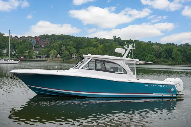 Slide: The Image of 2021 Southport 33 DC boat on a calm lake with lush green background. - 18