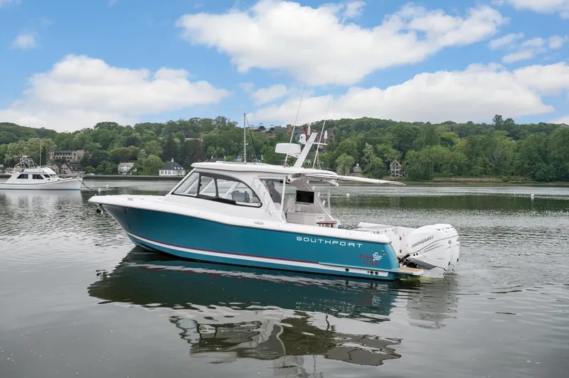 Slide: The Image of 2021 Southport 33 DC boat on a calm lake with scenic background. - 19