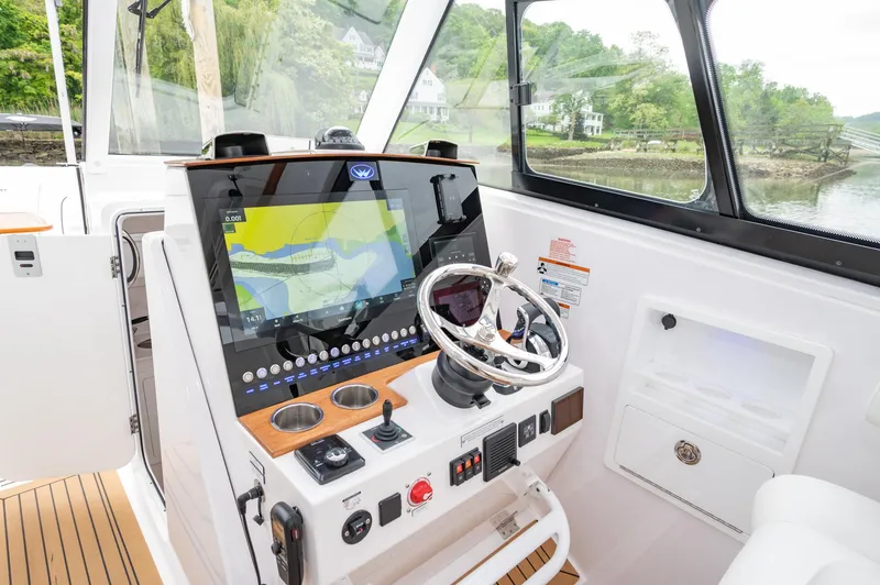 Slide: The Image of 2021 Southport 33 DC boat helm with advanced navigation system and scenic river view. - 27