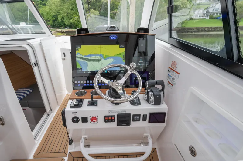 Slide: The Image of Cockpit of 2021 Southport 33 DC boat with navigation system and steering wheel. - 28