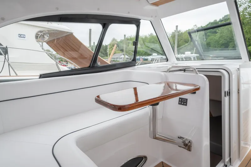 Slide: The Image of 2021 Southport 33 DC interior with sleek wooden table and white seating. - 30