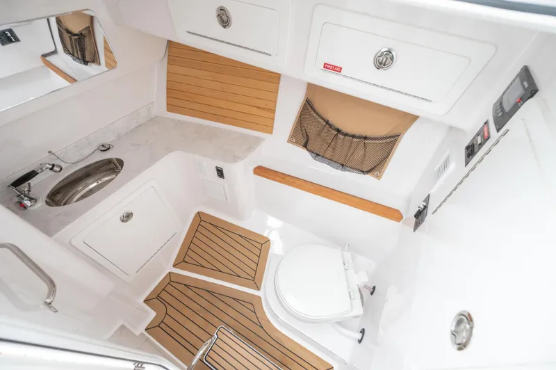 Slide: The Image of 2021 Southport 33 DC boat interior with sink, toilet, and wood accents. - 34