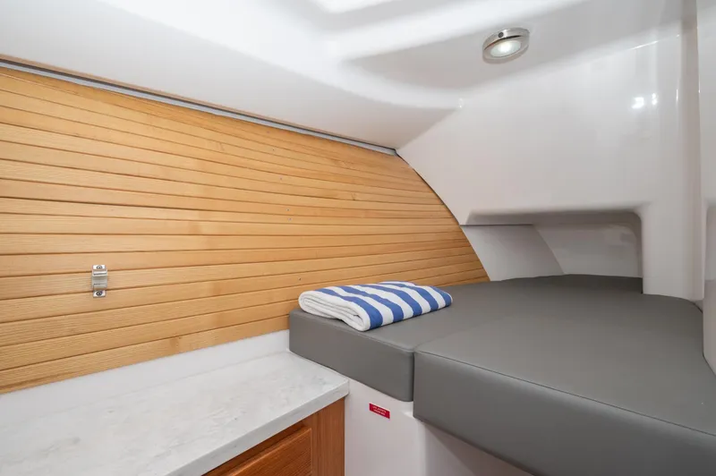Slide: The Image of 2021 Southport 33 DC cabin interior with wooden paneling and cushioned bed. - 35