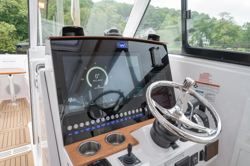 Slide: The Image of 2021 Southport 33 DC boat dashboard with modern controls and steering wheel. - 38