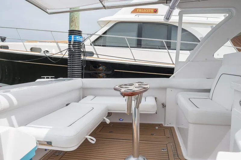 Slide: The Image of 2021 Southport 33 DC boat interior with white seating and wooden deck. - 42