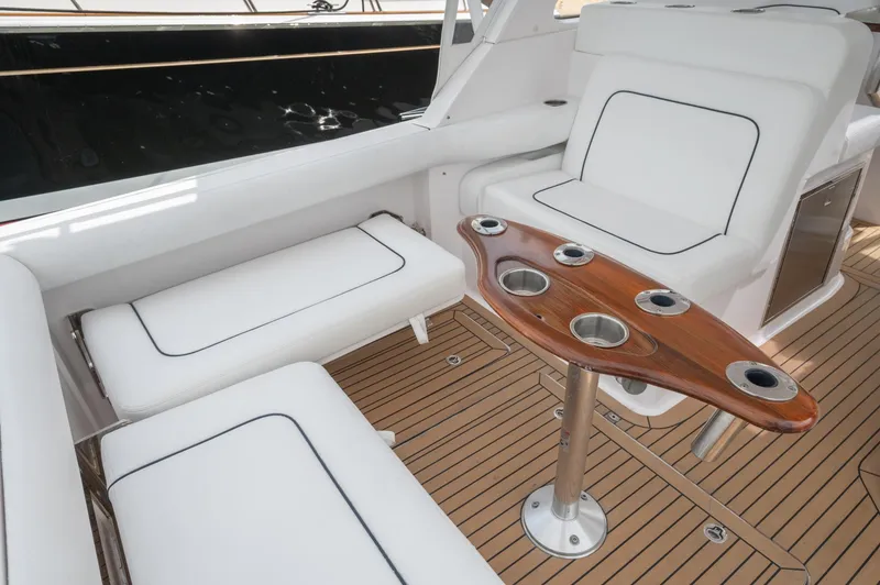 Slide: The Image of 2021 Southport 33 DC boat interior with white seating and wooden table. - 43