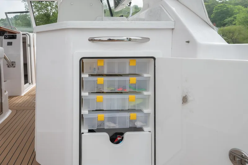 Slide: The Image of 2021 Southport 33 DC boat storage compartment with organized tackle boxes. - 46