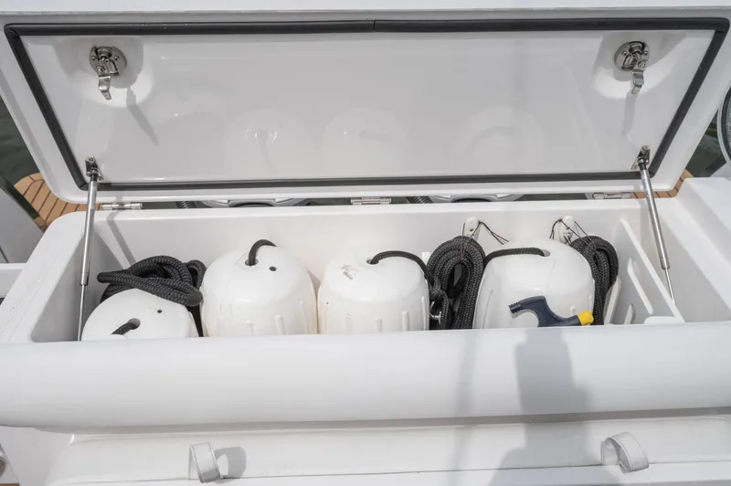 Slide: The Image of Open storage compartment on 2021 Southport 33 DC boat with fenders and ropes. - 47