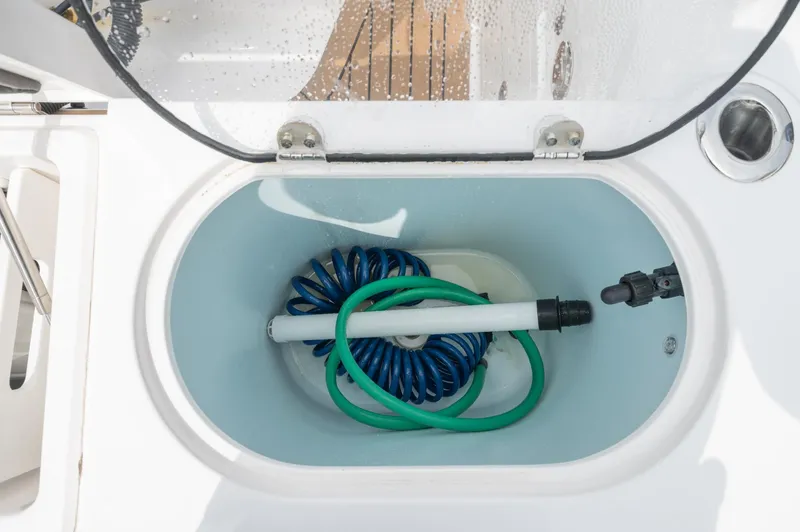 Slide: The Image of Storage compartment with coiled hoses on a 2021 Southport 33 DC boat. - 48