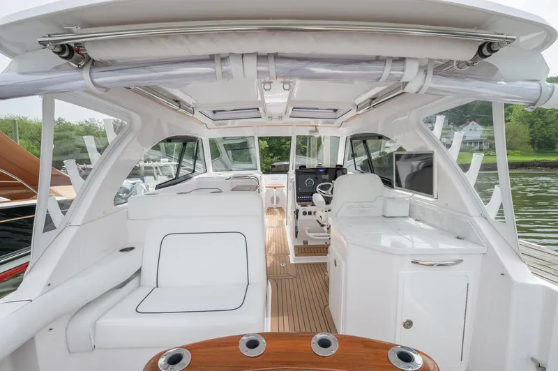 Slide: The Image of 2021 Southport 33 DC boat interior with white seating and wooden flooring. - 49